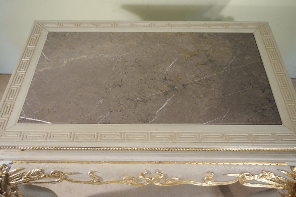 A grey painted rectangular centre table featuring ornate parcel-gilt leaf carvings on cabriole legs and an inset grey marble top. View XVII