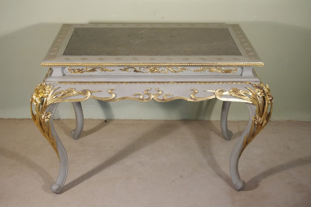 A grey painted rectangular centre table featuring ornate parcel-gilt leaf carvings on cabriole legs and an inset grey marble top. View XIX