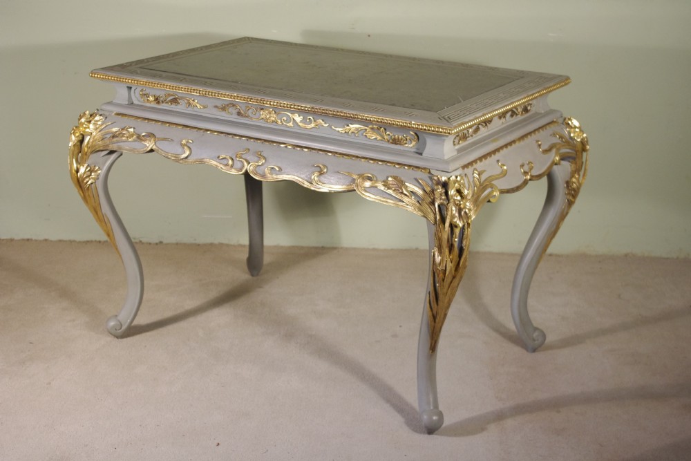 A grey painted rectangular centre table featuring ornate parcel-gilt leaf carvings on cabriole legs and an inset grey marble top.