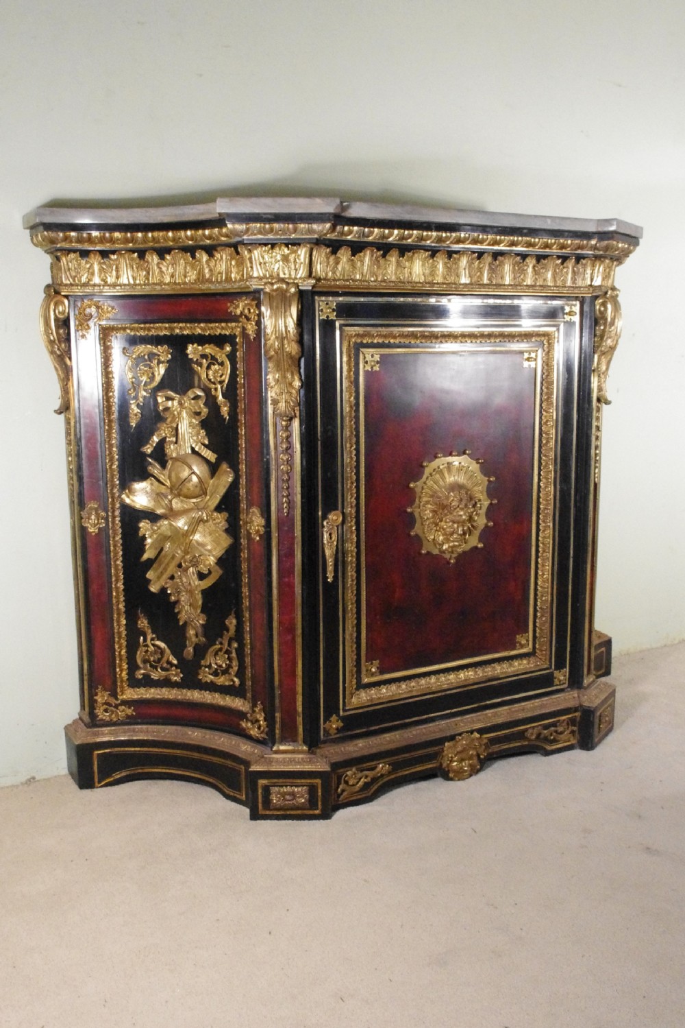A 19th-century French ebonised side cabinet featuring gilt-metal mounts, a central red panel with a classical medallion, and a contoured marble top. View V