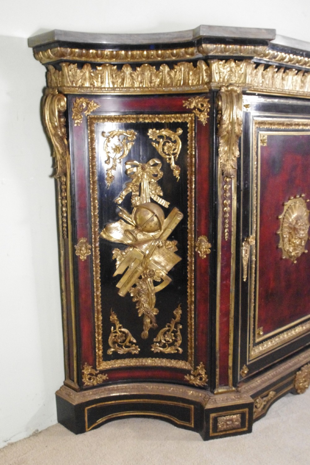 A 19th-century French ebonised side cabinet featuring gilt-metal mounts, a central red panel with a classical medallion, and a contoured marble top. View VI