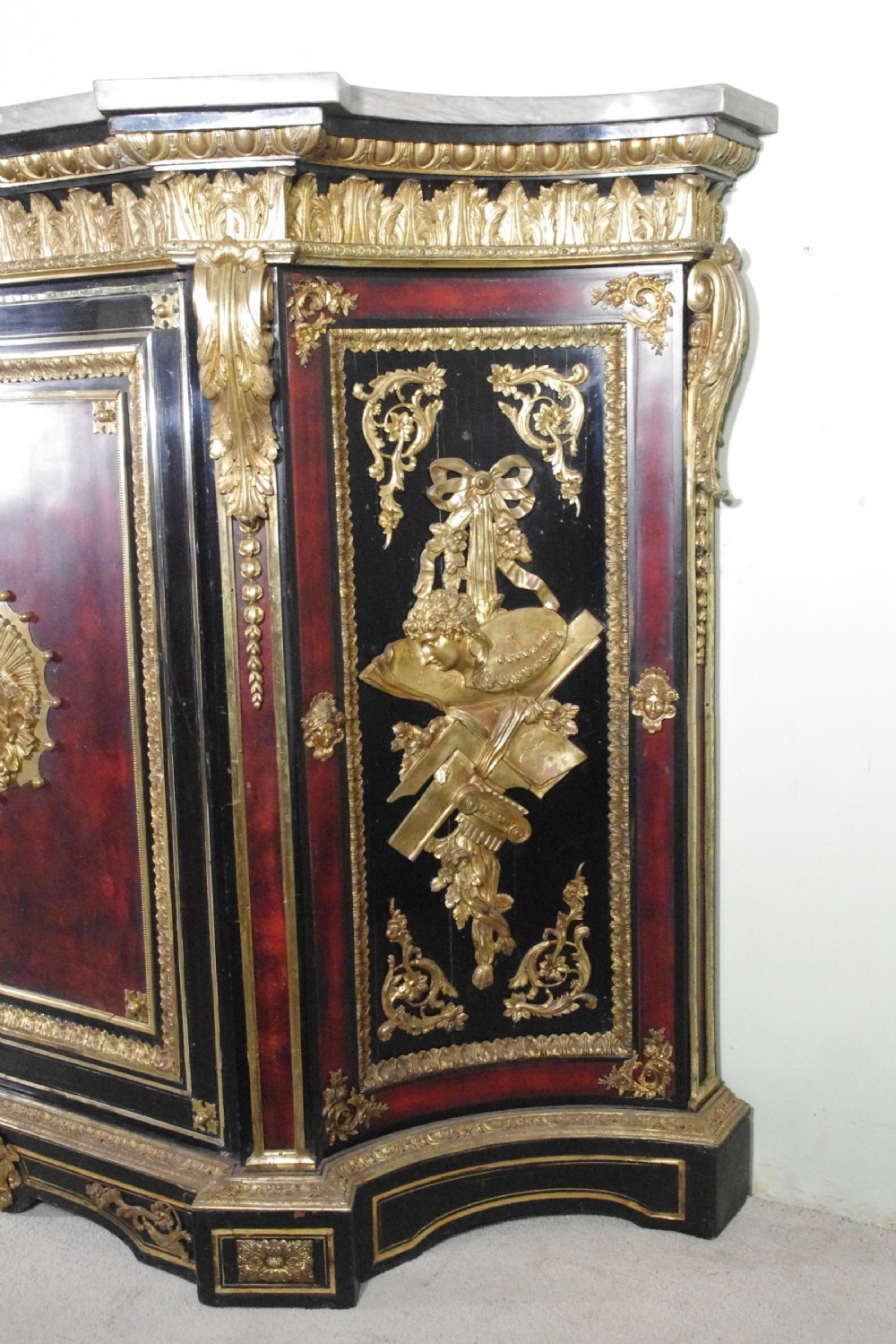 A 19th-century French ebonised side cabinet featuring gilt-metal mounts, a central red panel with a classical medallion, and a contoured marble top. View VII