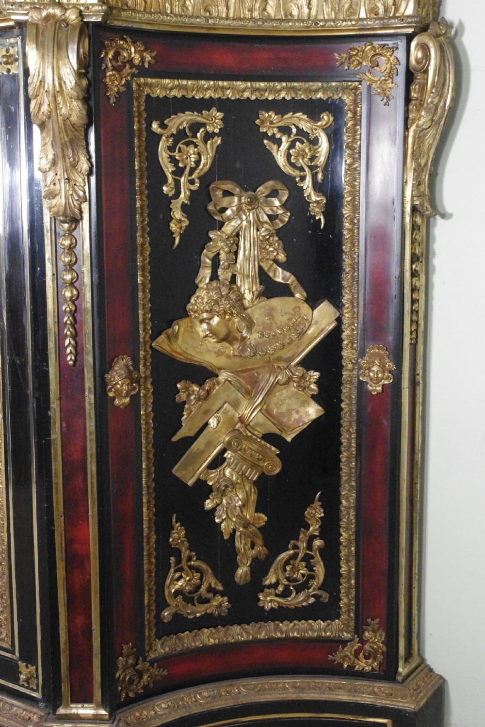 A 19th-century French ebonised side cabinet featuring gilt-metal mounts, a central red panel with a classical medallion, and a contoured marble top. View IX
