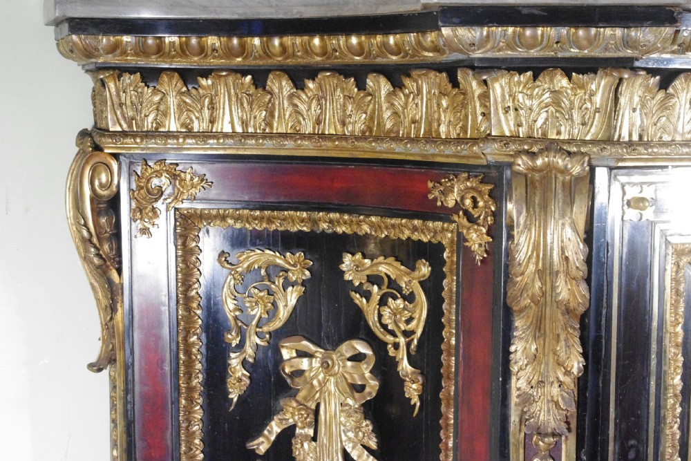 A 19th-century French ebonised side cabinet featuring gilt-metal mounts, a central red panel with a classical medallion, and a contoured marble top. View XVI