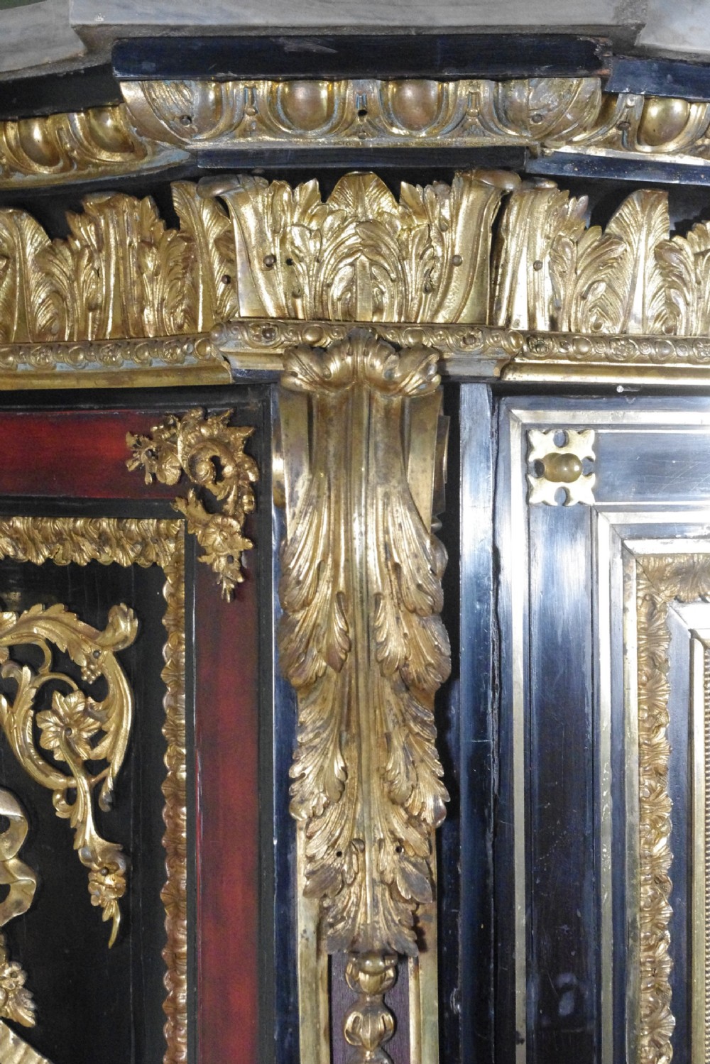 A 19th-century French ebonised side cabinet featuring gilt-metal mounts, a central red panel with a classical medallion, and a contoured marble top. View XXIII