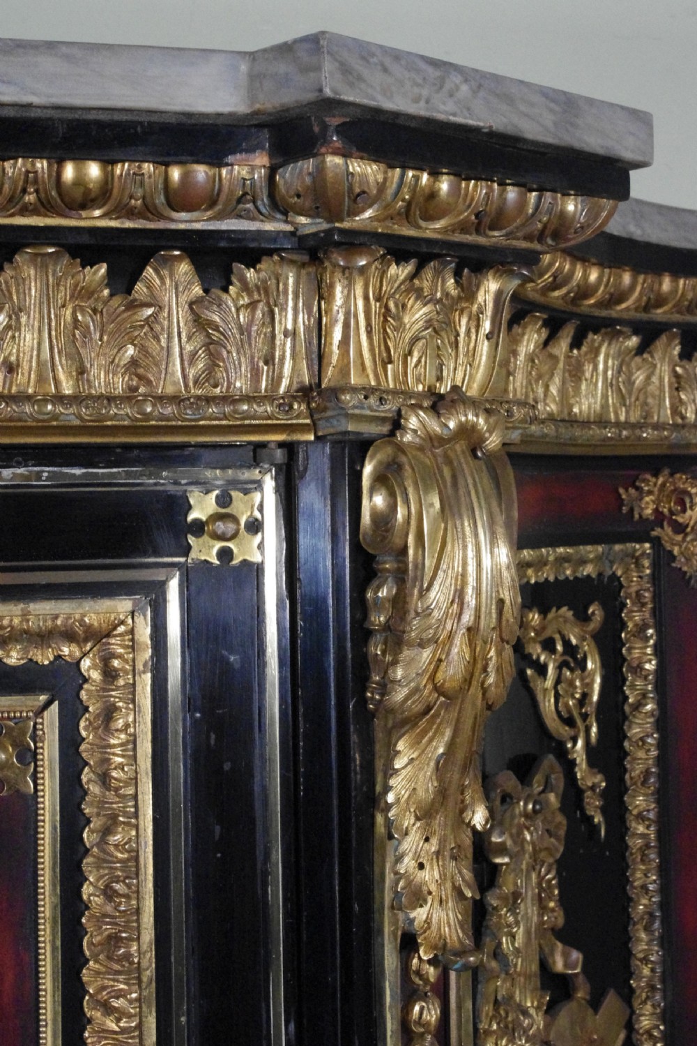 A 19th-century French ebonised side cabinet featuring gilt-metal mounts, a central red panel with a classical medallion, and a contoured marble top. View XXIV