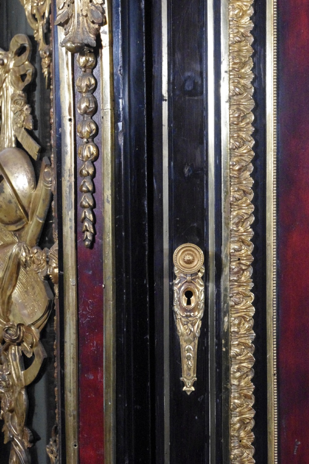 A 19th-century French ebonised side cabinet featuring gilt-metal mounts, a central red panel with a classical medallion, and a contoured marble top. View XXV