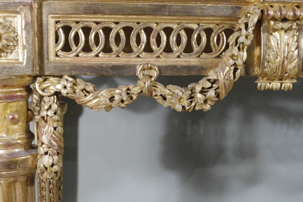 A Louis XVI style giltwood console table with a red veined marble top, carved floral drapes, an openwork frieze, and turned tapered legs. View XIII