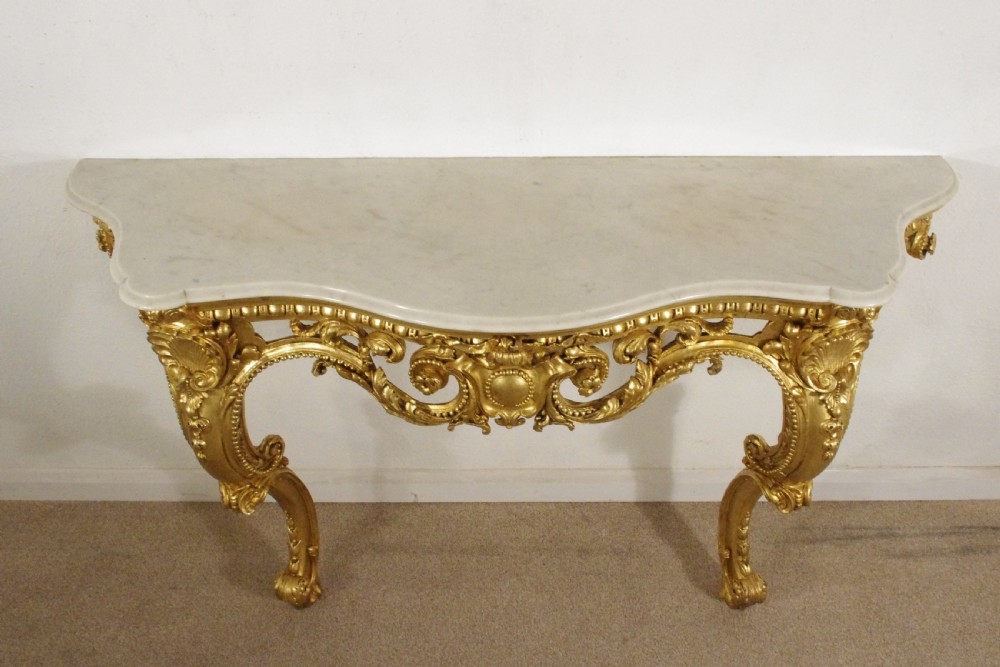 A 19th-century Rococo Revival giltwood console table featuring an ornate carved apron, cabriole legs, and a shaped white marble top. View III