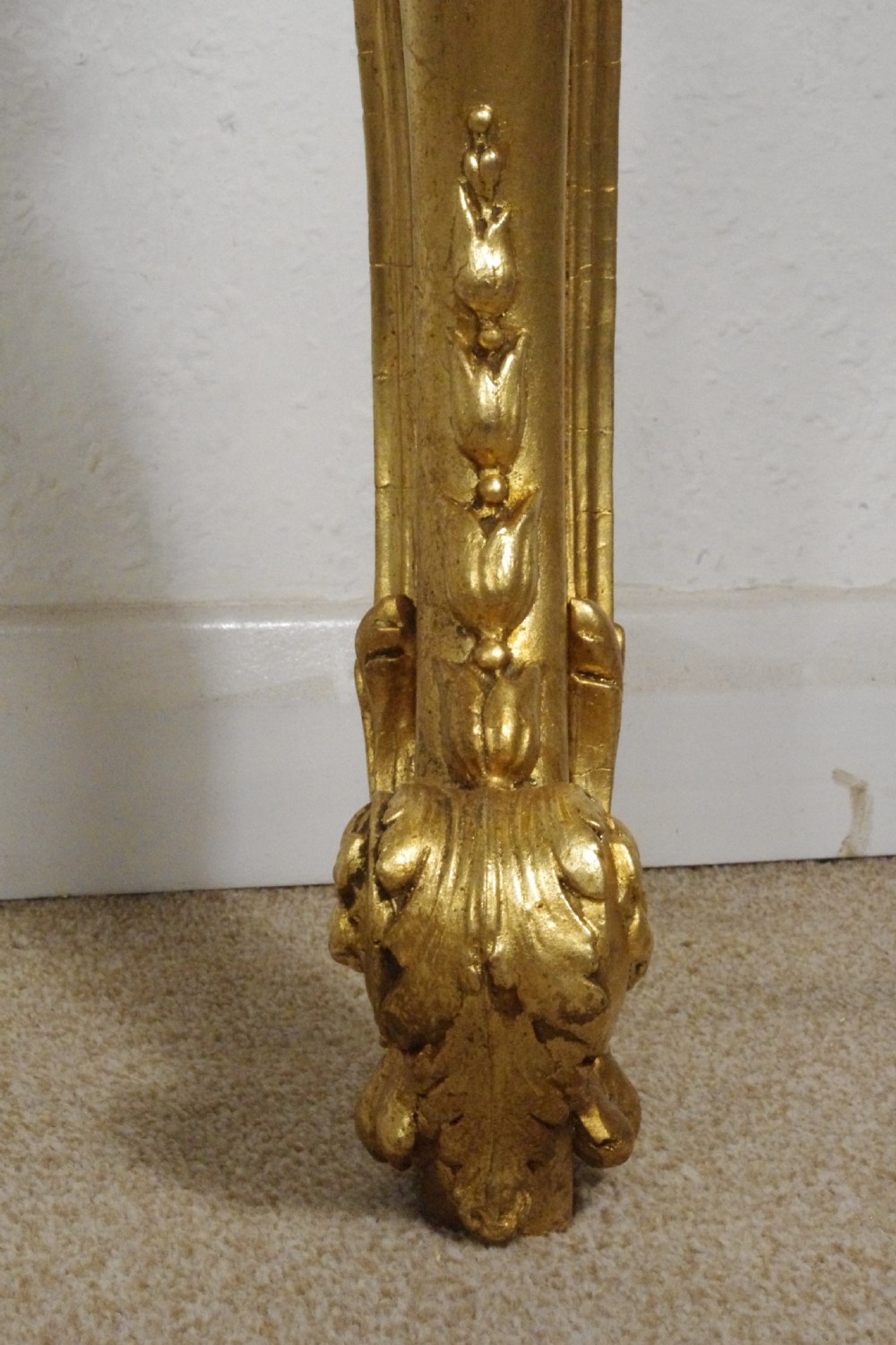 A 19th-century Rococo Revival giltwood console table featuring an ornate carved apron, cabriole legs, and a shaped white marble top. View XVIII