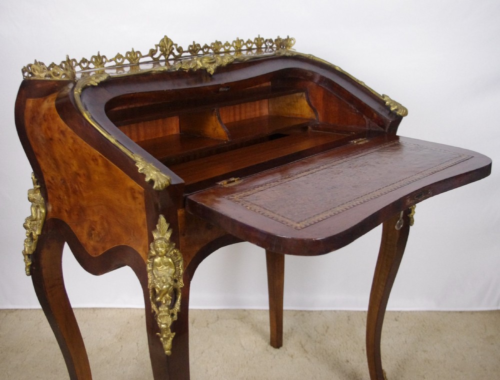 A French Louis XV style bureau de dame constructed from burr walnut veneer with cabriole legs and ornate gilt metal mounts. View VII