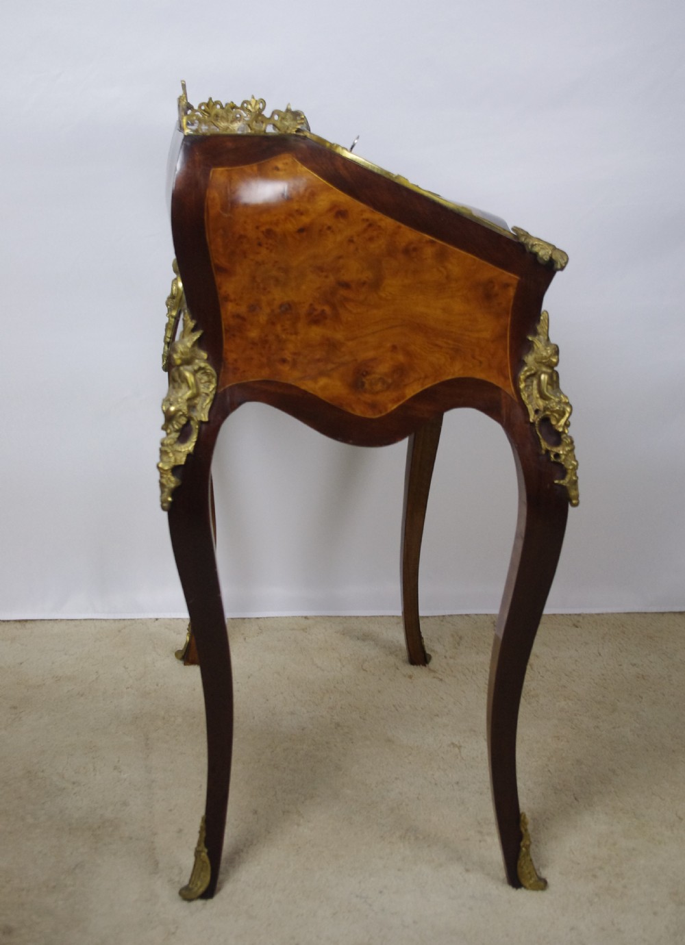 A French Louis XV style bureau de dame constructed from burr walnut veneer with cabriole legs and ornate gilt metal mounts. View XI