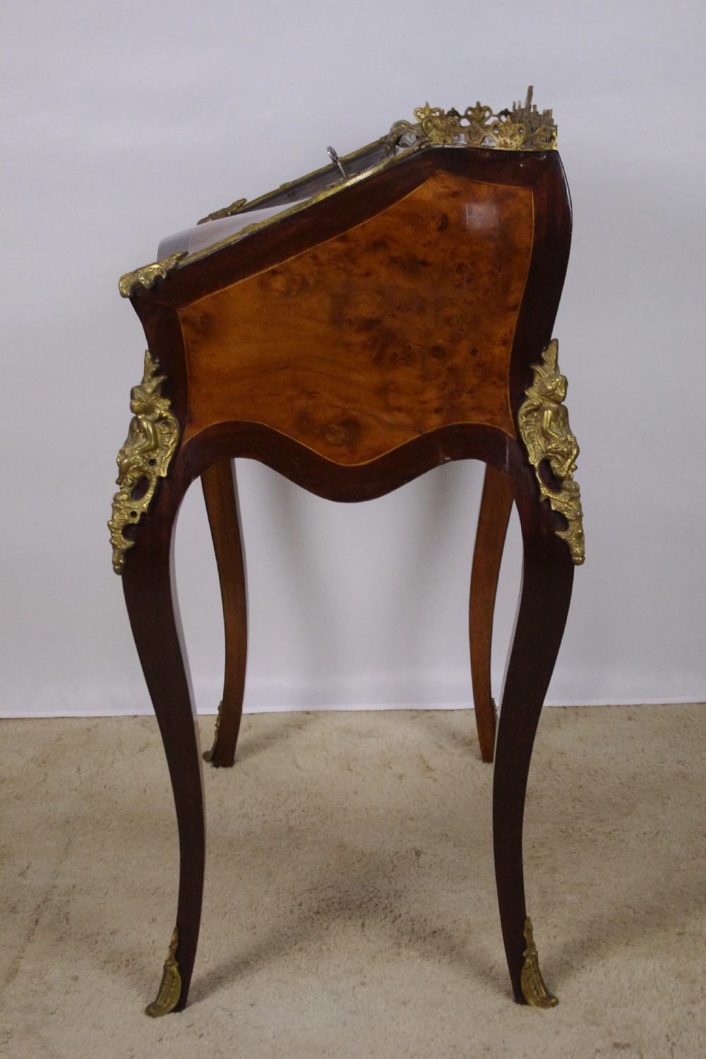 A French Louis XV style bureau de dame constructed from burr walnut veneer with cabriole legs and ornate gilt metal mounts. View XII
