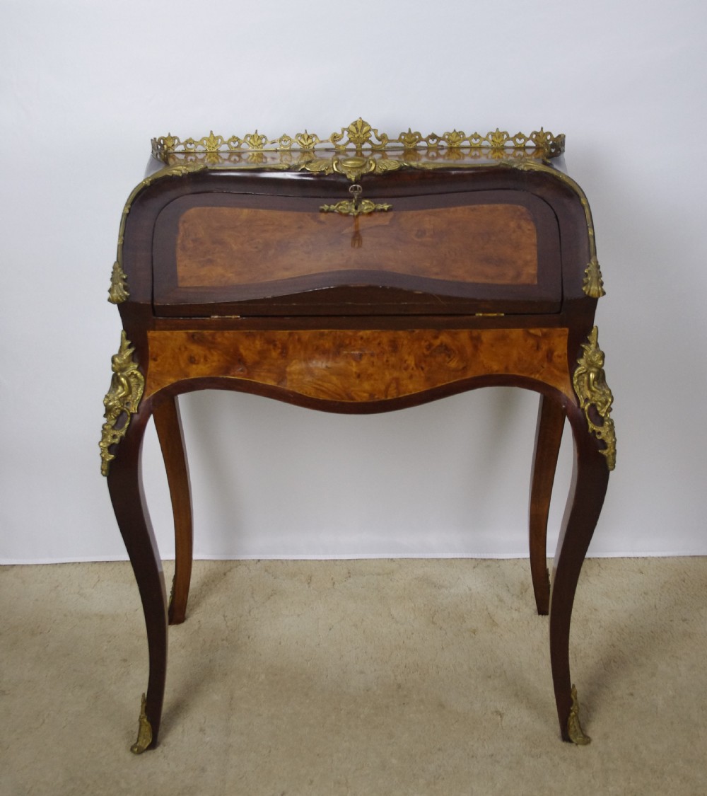 A French Louis XV style bureau de dame constructed from burr walnut veneer with cabriole legs and ornate gilt metal mounts. View II