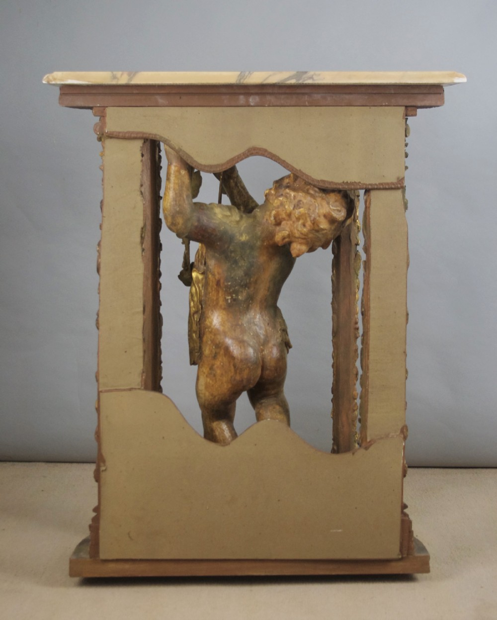 A 19th-century giltwood console table featuring a central carved putto figure with floral accents beneath a shaped marble top. View XVIII