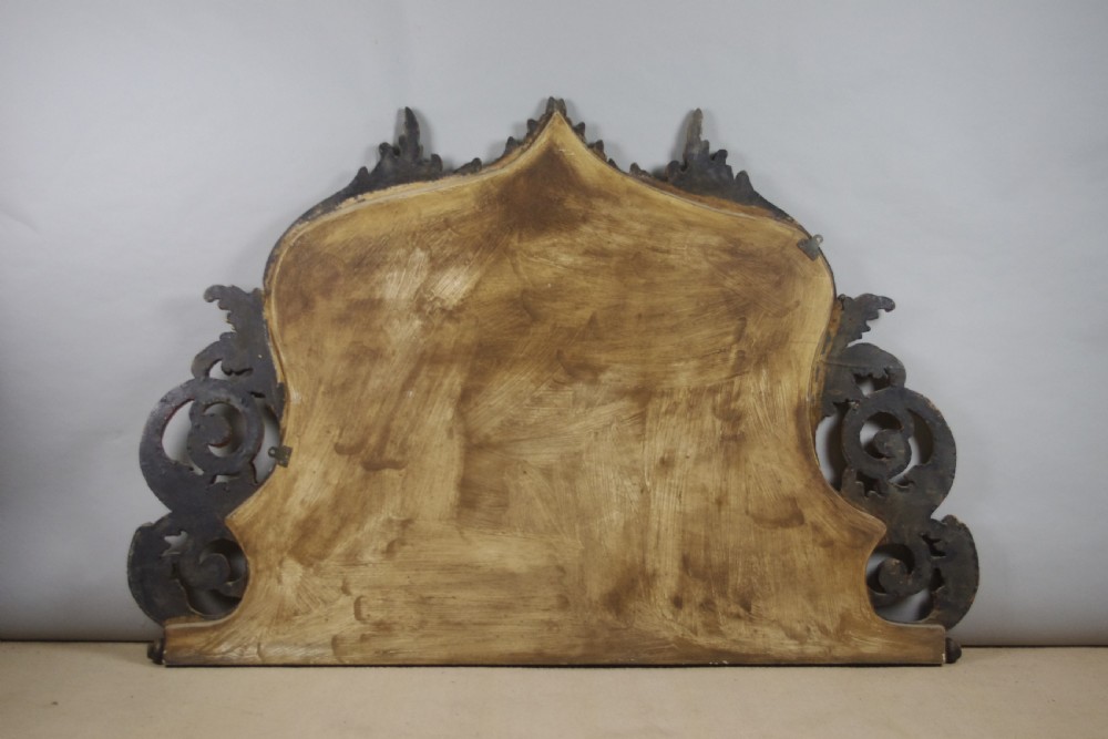 An ornate French giltwood overmantel mirror featuring carved acanthus leaf cresting along an arched frame with a straight base rail. View XI
