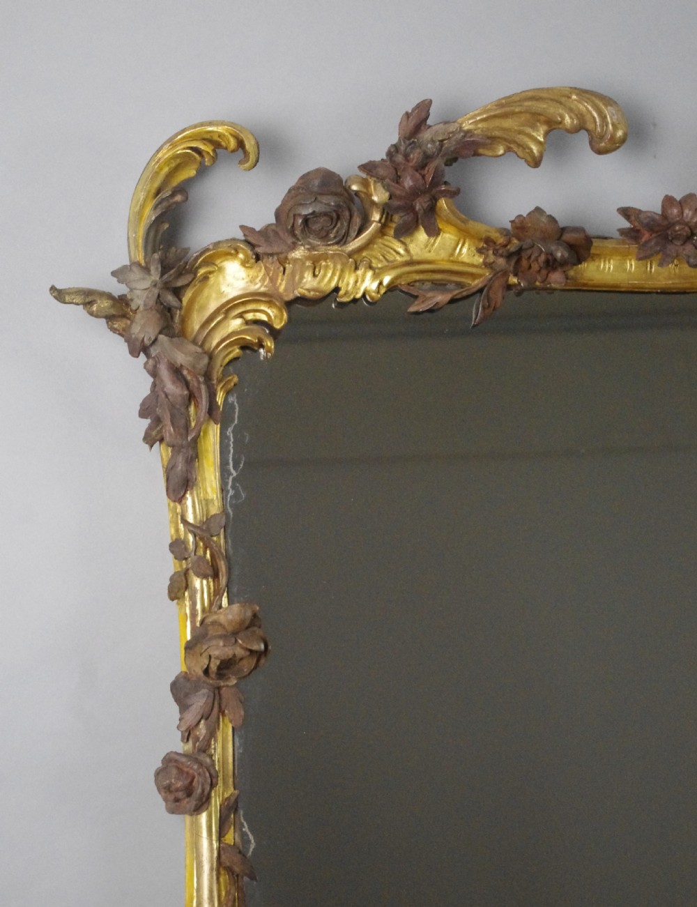 Large Victorian Rococo style giltwood overmantel mirror featuring elaborate carved foliate trails, asymmetric C-scrolls, and a scrolling top crest. View VI