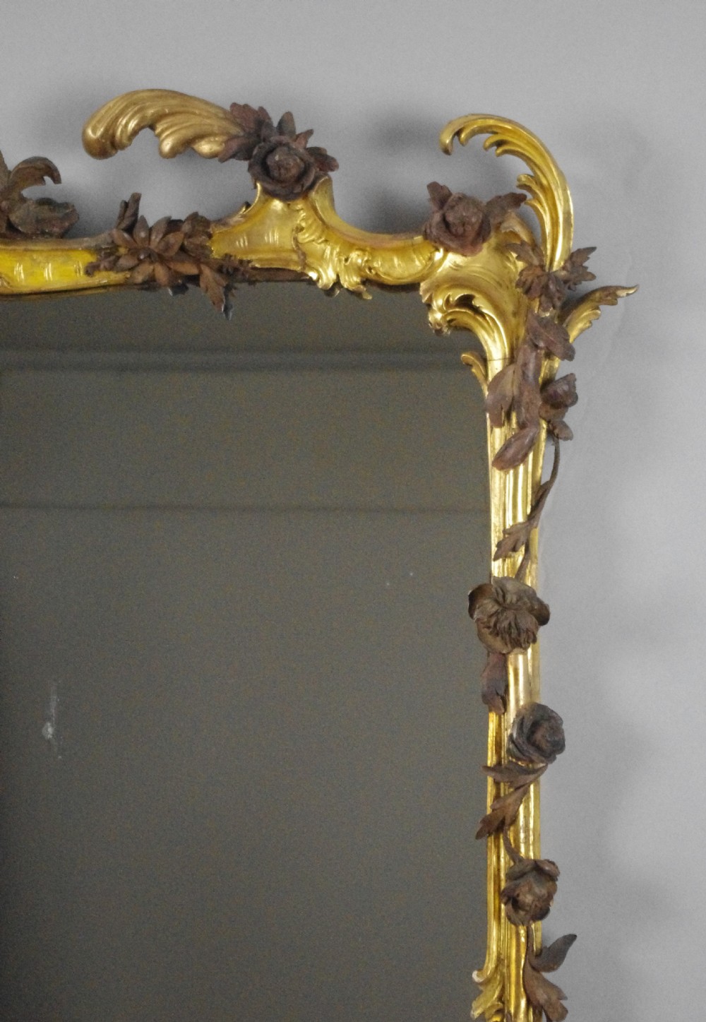 Large Victorian Rococo style giltwood overmantel mirror featuring elaborate carved foliate trails, asymmetric C-scrolls, and a scrolling top crest. View VII