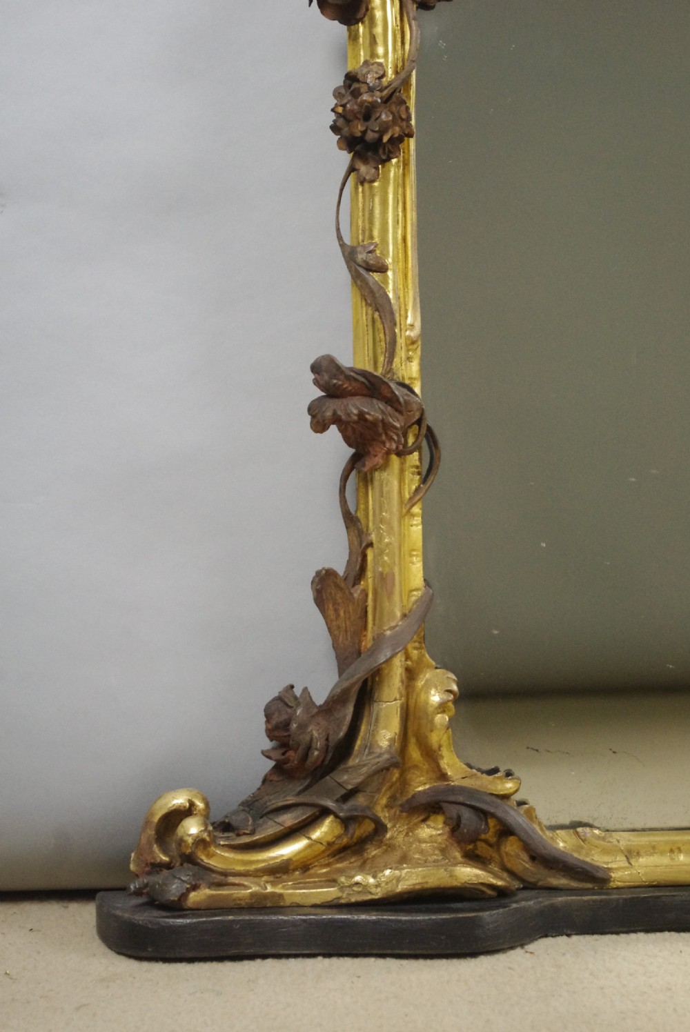 Large Victorian Rococo style giltwood overmantel mirror featuring elaborate carved foliate trails, asymmetric C-scrolls, and a scrolling top crest. View X