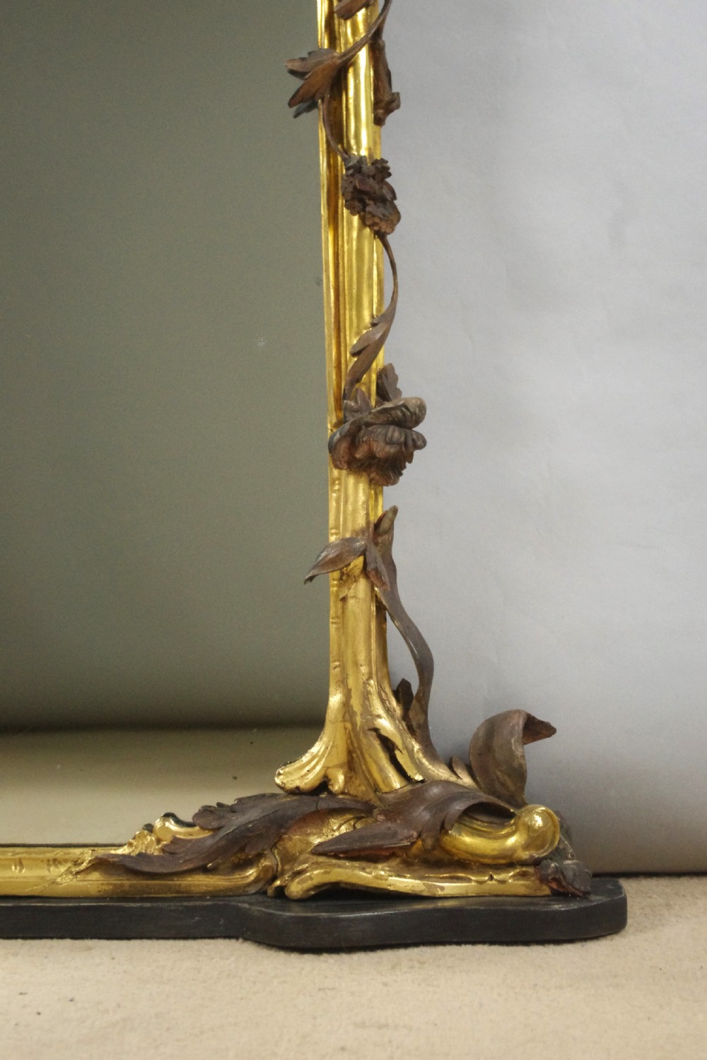 Large Victorian Rococo style giltwood overmantel mirror featuring elaborate carved foliate trails, asymmetric C-scrolls, and a scrolling top crest. View XI