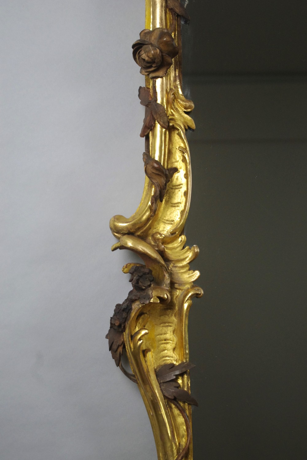 Large Victorian Rococo style giltwood overmantel mirror featuring elaborate carved foliate trails, asymmetric C-scrolls, and a scrolling top crest. View XII