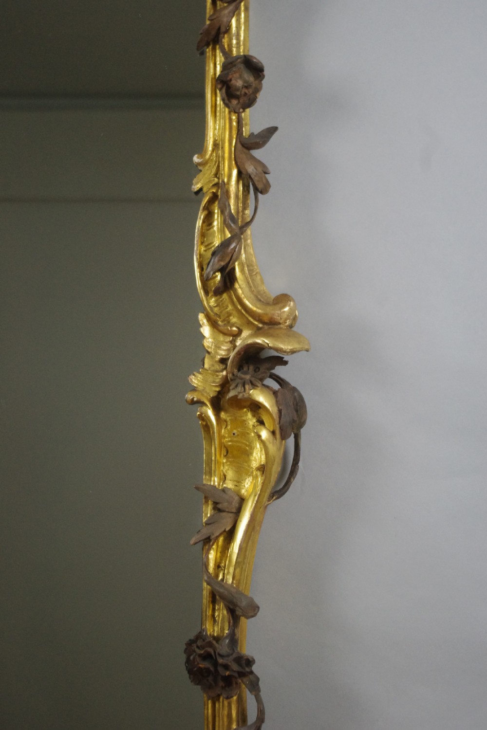 Large Victorian Rococo style giltwood overmantel mirror featuring elaborate carved foliate trails, asymmetric C-scrolls, and a scrolling top crest. View XIII
