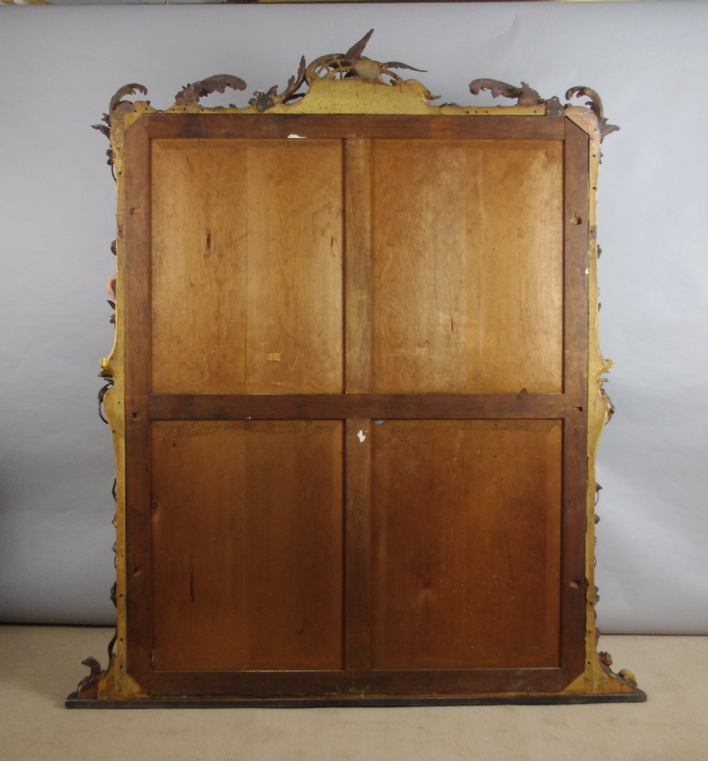 Large Victorian Rococo style giltwood overmantel mirror featuring elaborate carved foliate trails, asymmetric C-scrolls, and a scrolling top crest. View XV