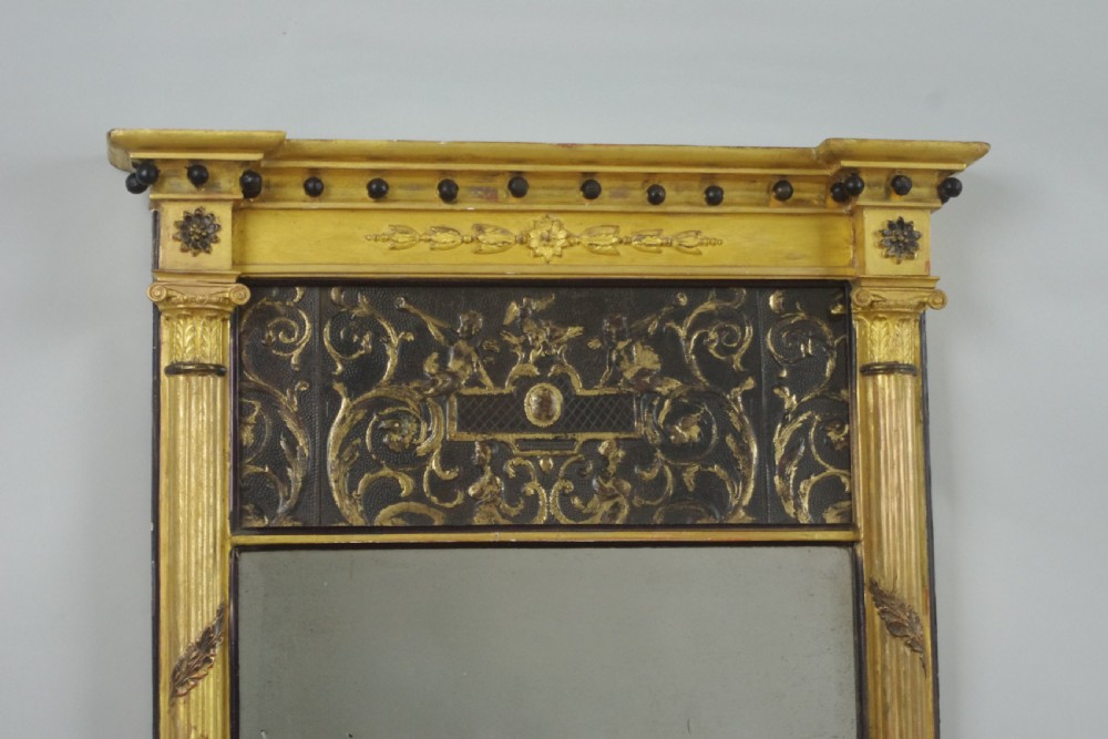 A tall rectangular Regency giltwood pier mirror featuring fluted pilasters, spherule cornice details, and a decorative foliate frieze panel above the glass. View II
