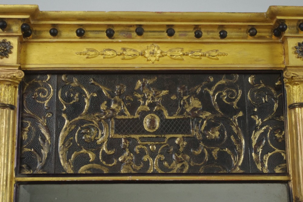 A tall rectangular Regency giltwood pier mirror featuring fluted pilasters, spherule cornice details, and a decorative foliate frieze panel above the glass. View III