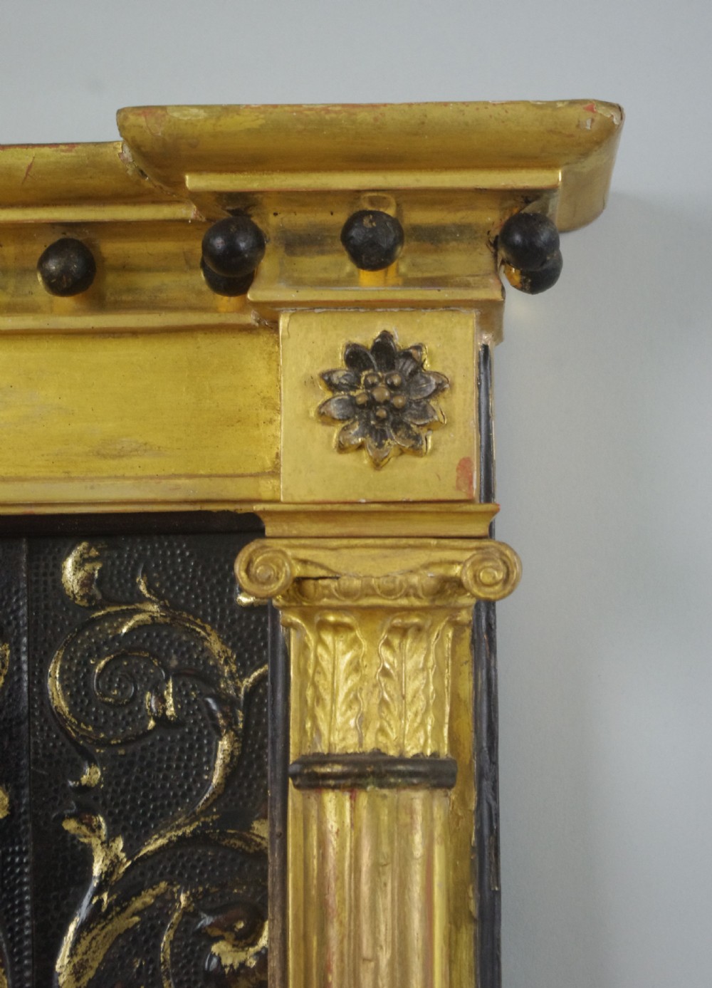 A tall rectangular Regency giltwood pier mirror featuring fluted pilasters, spherule cornice details, and a decorative foliate frieze panel above the glass. View V
