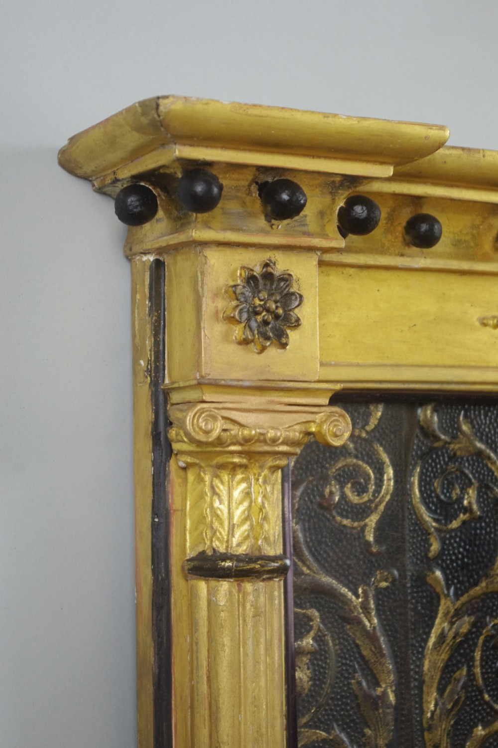 A tall rectangular Regency giltwood pier mirror featuring fluted pilasters, spherule cornice details, and a decorative foliate frieze panel above the glass. View VI