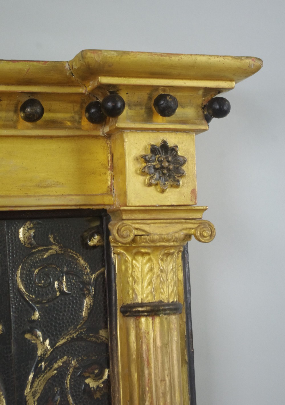 A tall rectangular Regency giltwood pier mirror featuring fluted pilasters, spherule cornice details, and a decorative foliate frieze panel above the glass. View VII