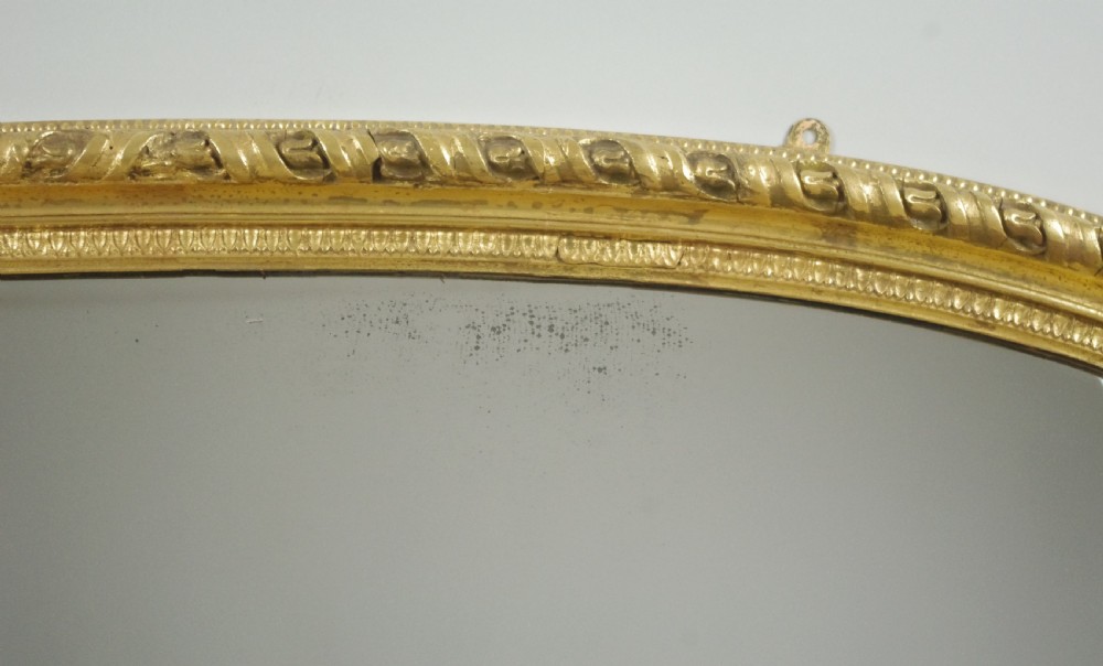 A Victorian arched overmantel mirror featuring a gilded frame with rope-twist detail and a flat base. View VI