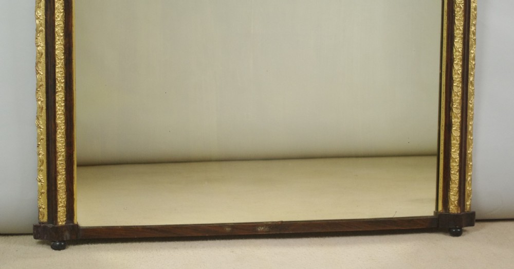 A large Victorian arched overmantel mirror featuring a simulated dark wood frame with detailed parcel-gilt foliage moulding along the inner and outer borders. View IX