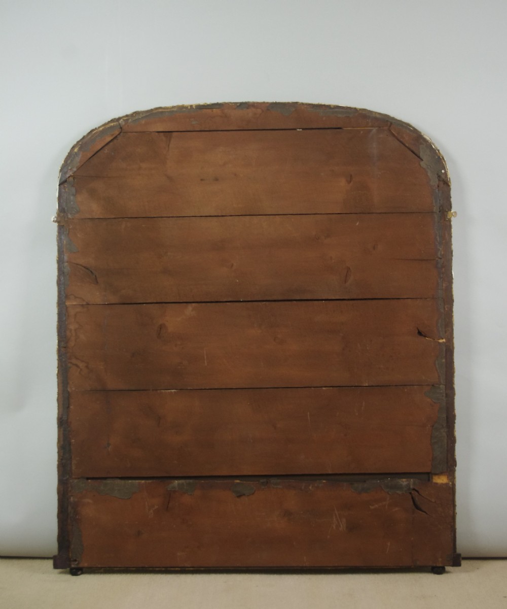A large Victorian arched overmantel mirror featuring a simulated dark wood frame with detailed parcel-gilt foliage moulding along the inner and outer borders. View XI
