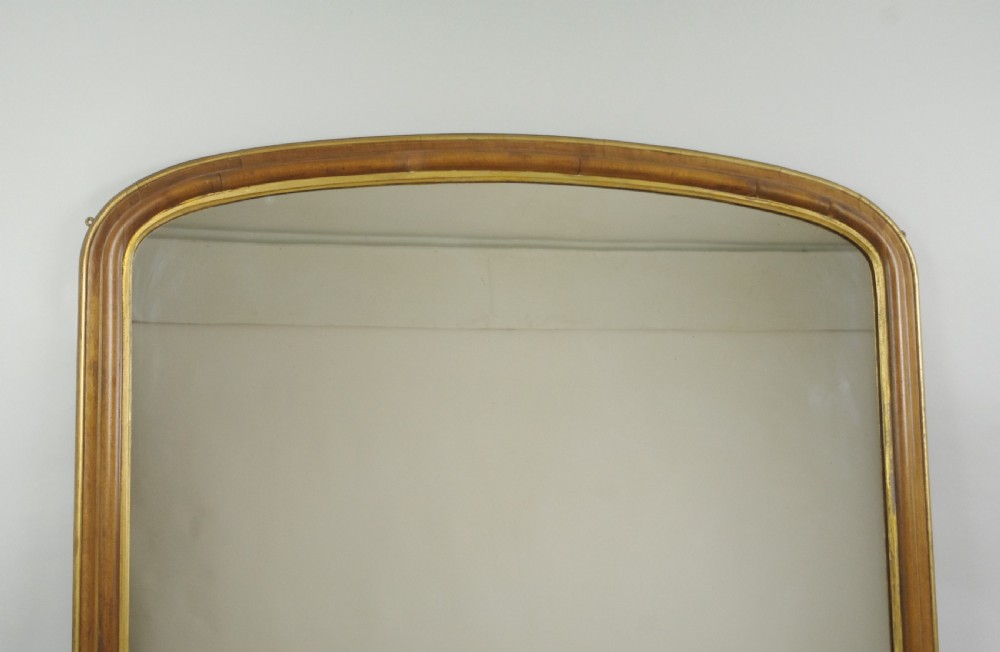 A large Victorian arch-top overmantel mirror with a moulded oak frame, parcel-gilt inner rim, and carved scroll bases. View II