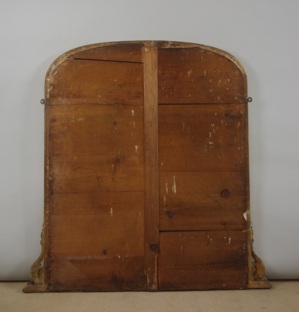 A Victorian giltwood overmantel mirror featuring an arched top frame, beaded relief moulding, and decorative scrollwork supports at the base. View VIII