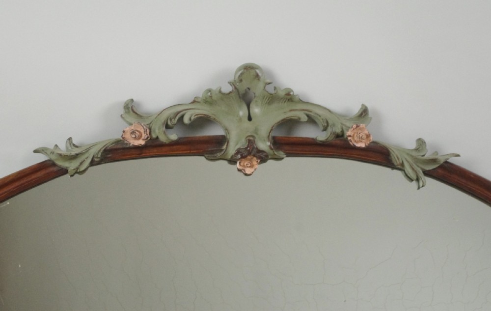 A Victorian arch-top mahogany overmantel mirror with carved sage green scrolling foliage and pale pink painted flowers around the frame. View II