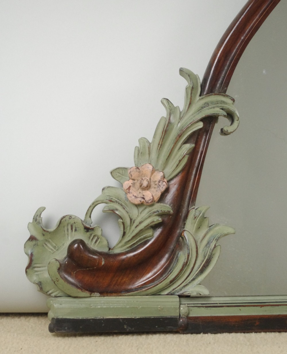 A Victorian arch-top mahogany overmantel mirror with carved sage green scrolling foliage and pale pink painted flowers around the frame. View IV