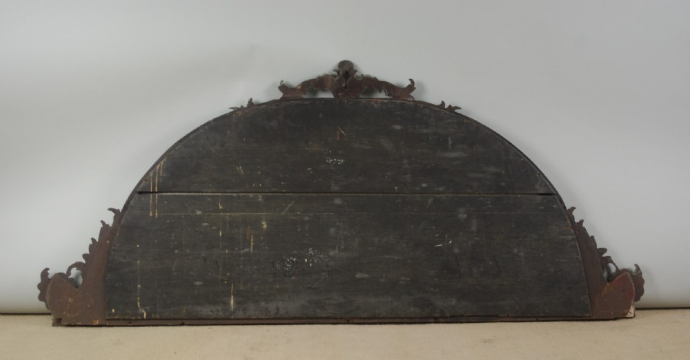 A Victorian arch-top mahogany overmantel mirror with carved sage green scrolling foliage and pale pink painted flowers around the frame. View VII