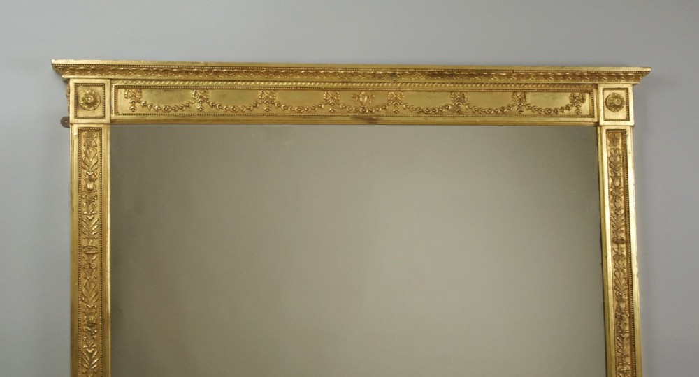A large rectangular Victorian gilt overmantel mirror featuring Neoclassical swags, rosettes, and beaded moulding along the frame. View III