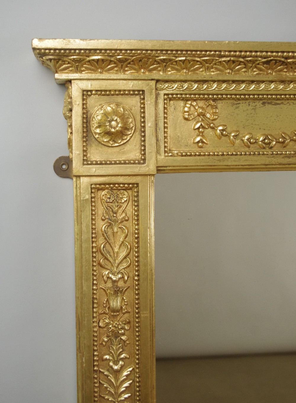 A large rectangular Victorian gilt overmantel mirror featuring Neoclassical swags, rosettes, and beaded moulding along the frame. View V