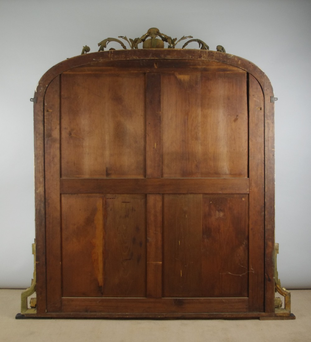 A large Victorian giltwood overmantel mirror featuring an arched top frame topped with an elaborate carved shell cresting. View X