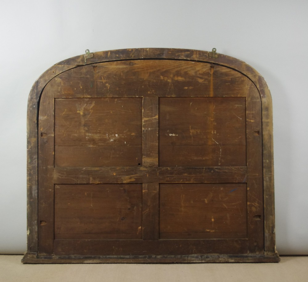 A large Victorian arched overmantel mirror featuring a gold giltwood frame with leaf moulding and a flat base. View X