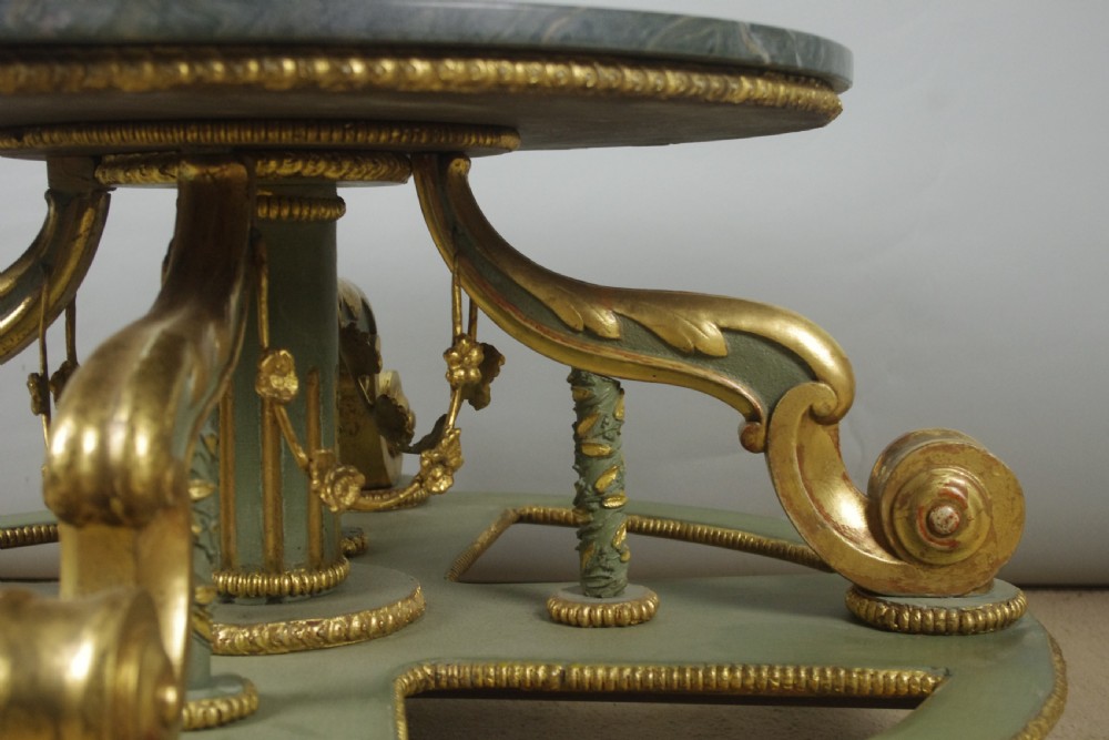 A low circular French Neoclassical style centre table featuring a dark green marble top and a sage green painted base with carved parcel-gilt scroll supports. View VII