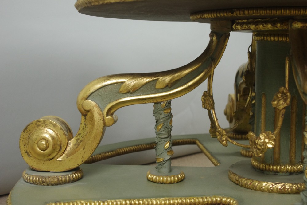 A low circular French Neoclassical style centre table featuring a dark green marble top and a sage green painted base with carved parcel-gilt scroll supports. View VIII