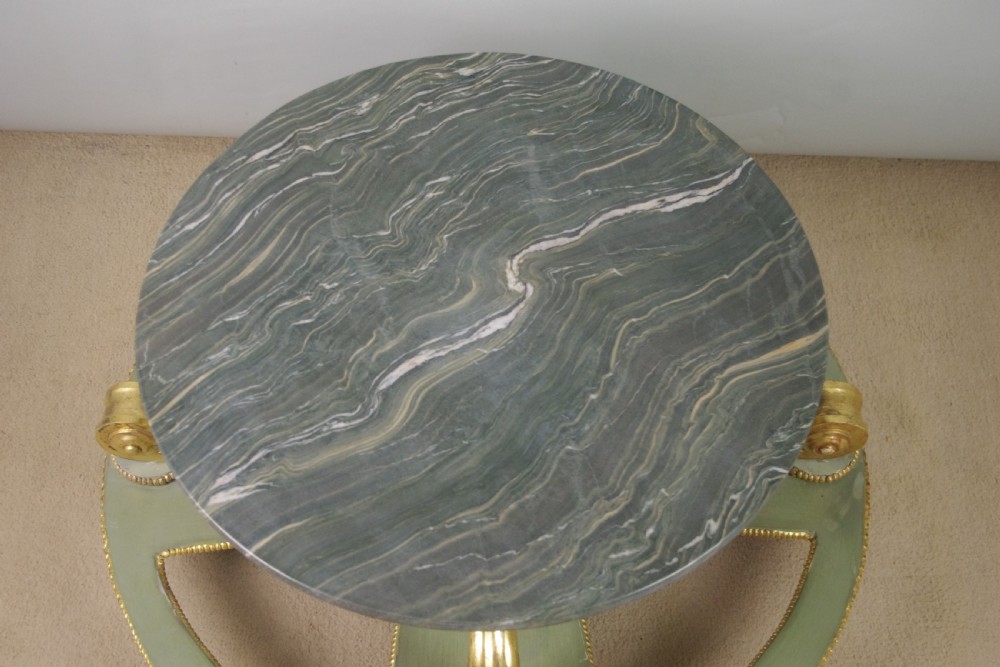 A low circular French Neoclassical style centre table featuring a dark green marble top and a sage green painted base with carved parcel-gilt scroll supports. View XI