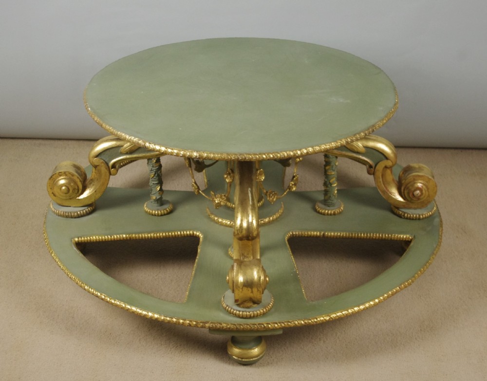 A low circular French Neoclassical style centre table featuring a dark green marble top and a sage green painted base with carved parcel-gilt scroll supports. View XIII