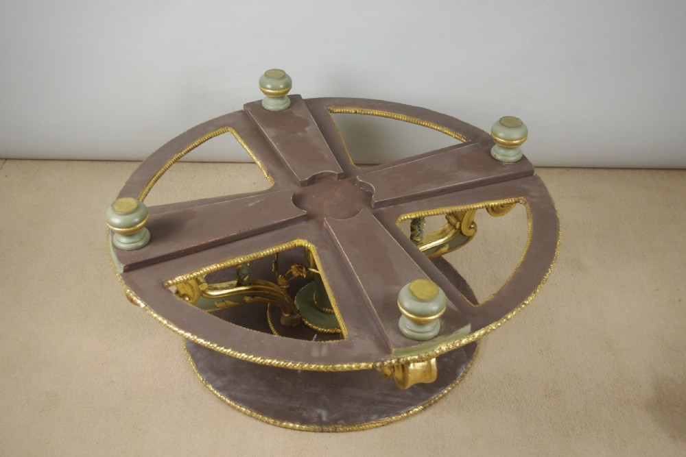 A low circular French Neoclassical style centre table featuring a dark green marble top and a sage green painted base with carved parcel-gilt scroll supports. View XIV