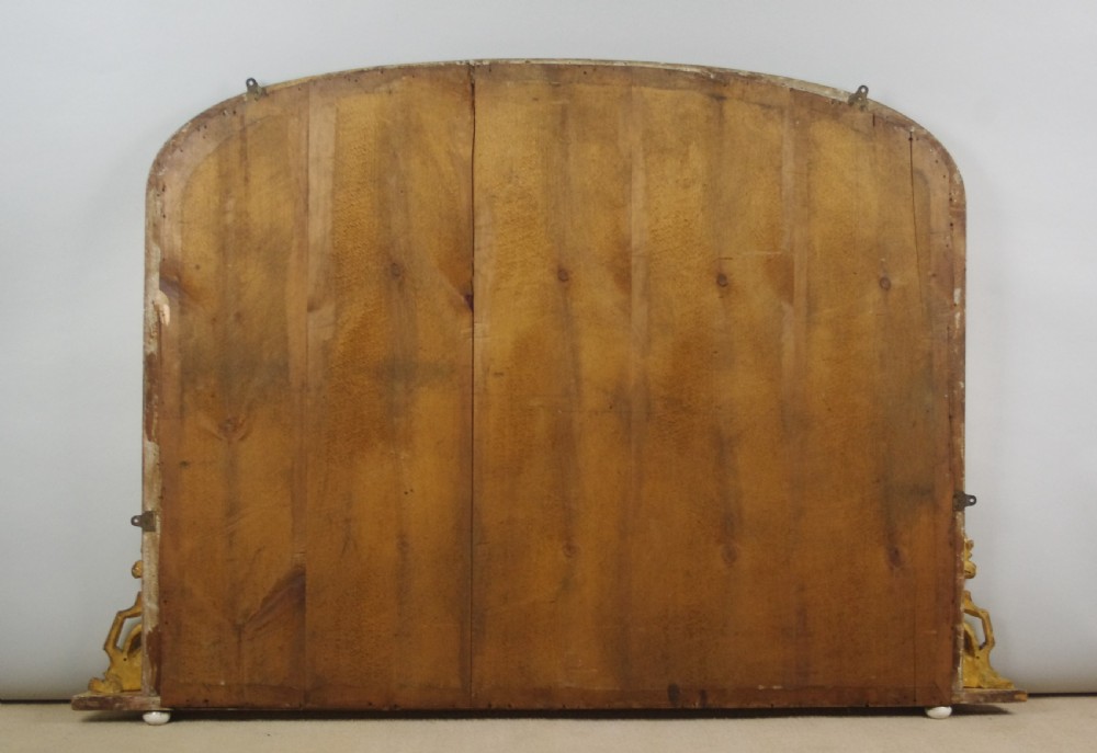 A large Victorian arched overmantel mirror featuring a gilded wood frame with decorative scroll side corbels. View XI